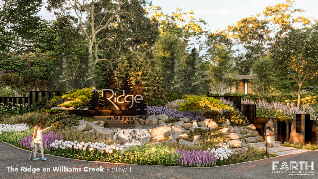 Entrance of The Ridge on Williams Creek featuring landscaped gardens with lush greenery, purple and white flowers, and a prominent sign, under a soft daylight ambiance.